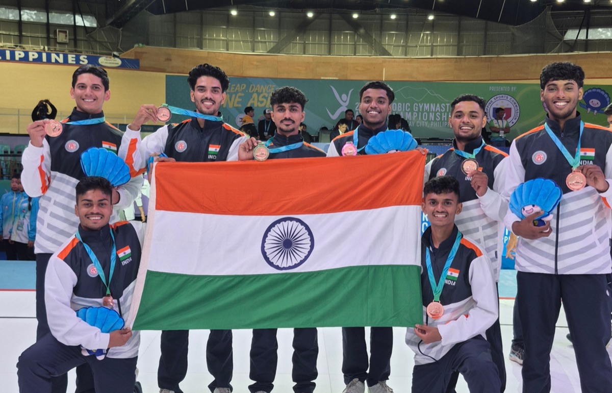 India's senior men's aero step team holding the national flag and bronze medals